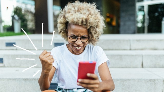 Woman sits on steps with her phone.