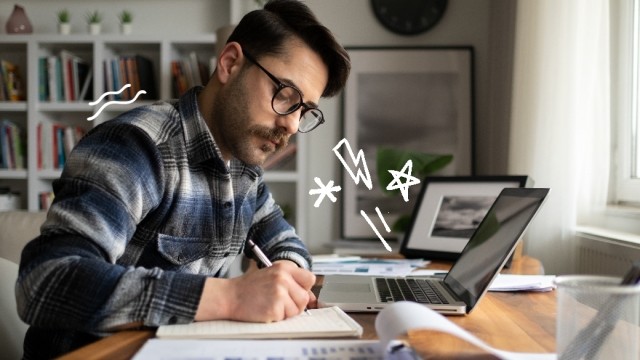 Man writes on a pad of paper in front of a laptop with doodles in the air around him.