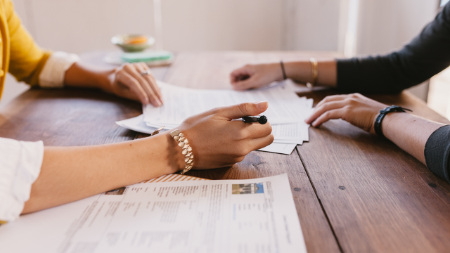 Two women reviewing home offer paperwork