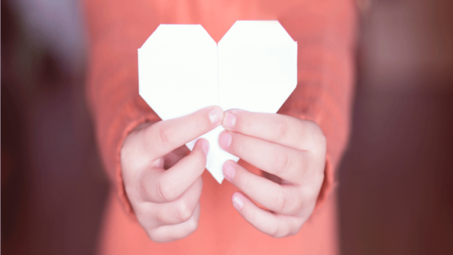 Person holding paper heart