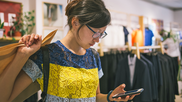 Young woman checking phone after making a purchase