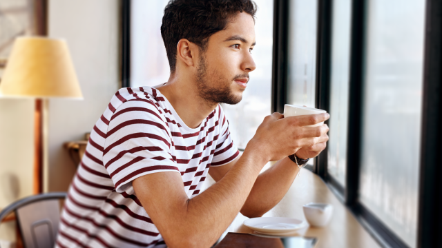 Young man staring out coffee shop window