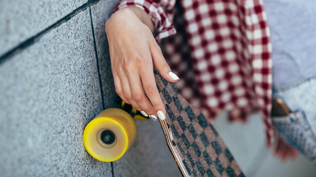 Hand of a young woman with a skateboard