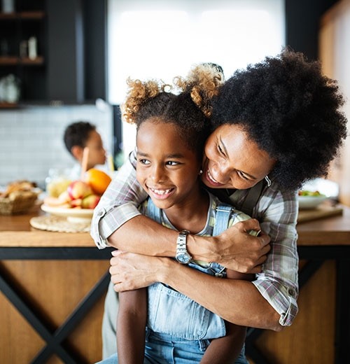 Mom and daughter embrace in kitchen